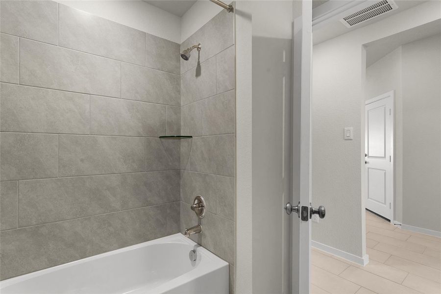 Full bathroom featuring a stall shower, a walk in closet, and light colored carpet