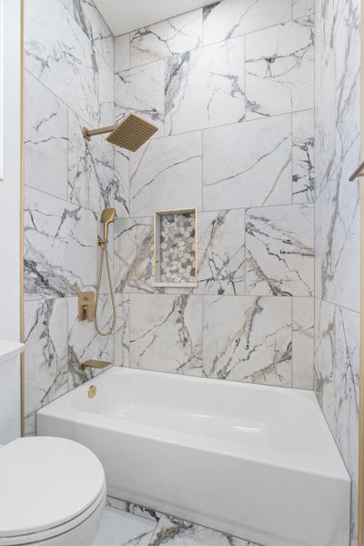 Full bathroom featuring a combined bath / shower with marble appearance and marble tiled flooring