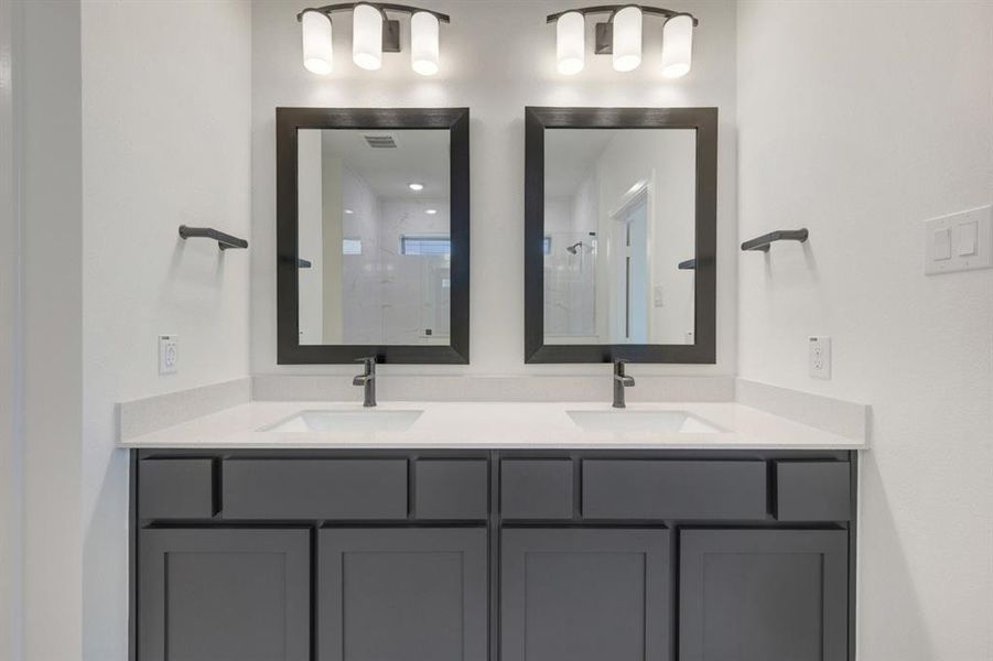 Dual vanity with grey shaker-style cabinetry, white countertops, and integrated rectangular sinks