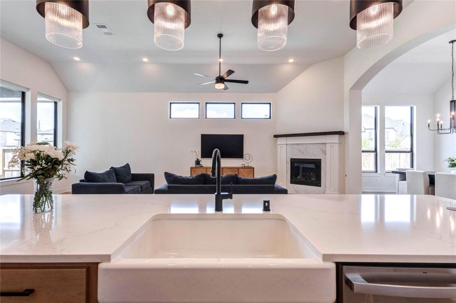 This modern kitchen features sleek, dual-tone cabinetry with ample storage, a large island with a farmhouse sink, stainless steel appliances, and elegant pendant lighting. The open layout extends to a dining area with natural light and a stylish chandelier. This modern kitchen features sleek, dual-tone cabinetry with ample storage, a large island with a farmhouse sink, stainless steel appliances, and elegant pendant lighting. The open layout extends to a dining area with natural light and a stylish chandelier.