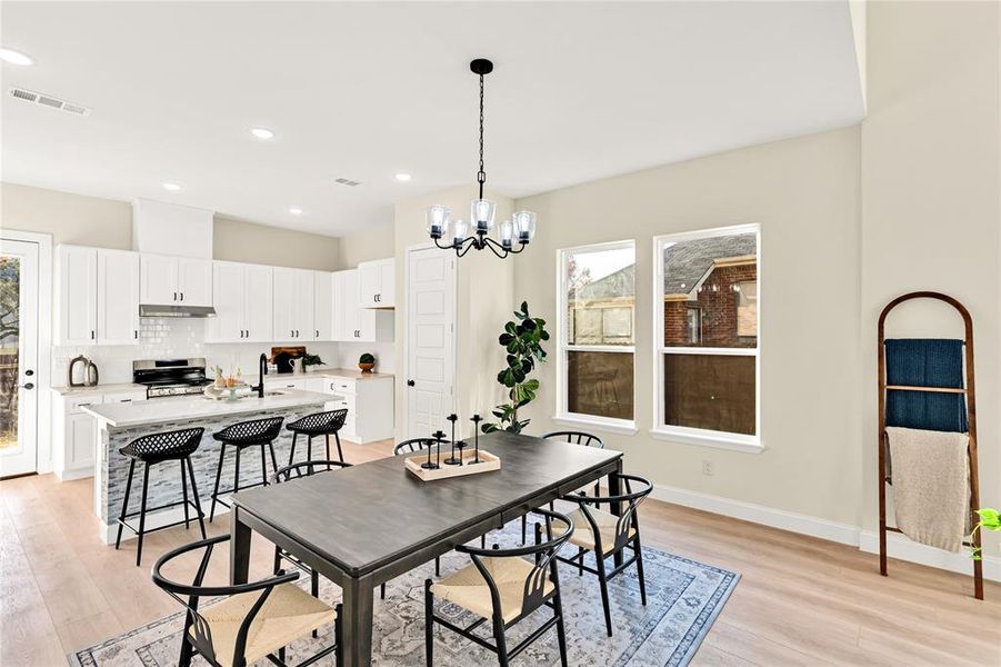 Dining space with light wood-type flooring, sink, and a chandelier