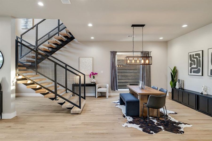 Dining space with a notable chandelier and light hardwood / wood-style flooring