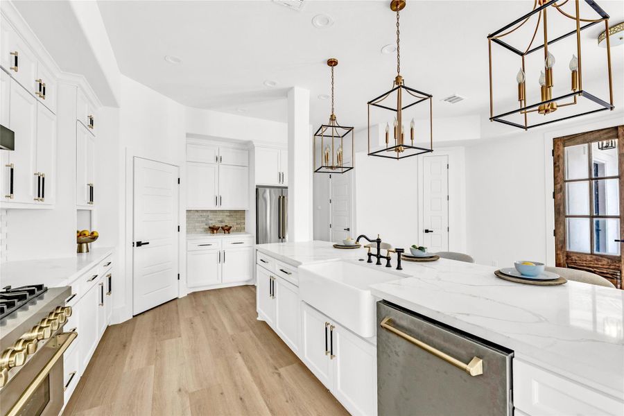 The kitchen impresses with quartz countertops, an expansive 11-foot island, and high-end designer finishes The kitchen impresses with quartz countertops, an expansive 11-foot island, and high-end designer finishes