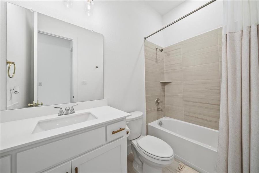 Bathroom with toilet, shower / bath combo, and vanity