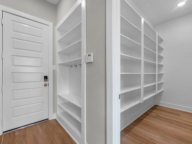 This home features a spacious walk-in pantry, providing ample storage to keep your kitchen organized and clutter-free. Adjacent, the thoughtfully designed mudroom offers a perfect spot for your family to hang coats, bags, and everyday essentials. It’s a functional yet stylish area that keeps everything in place, adding convenience to your daily routine.