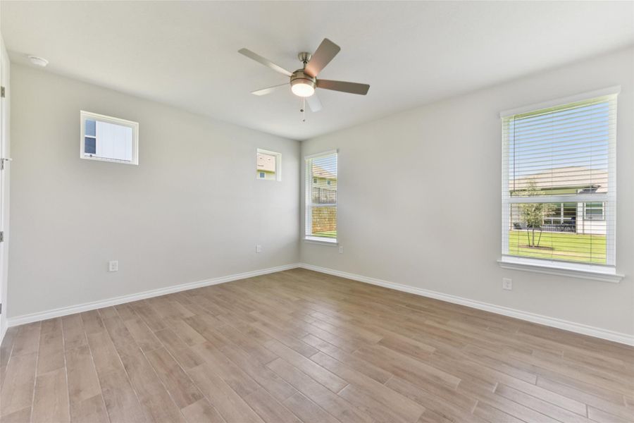 Unfurnished room with light wood-type flooring and a ceiling fan Unfurnished room with light wood-type flooring and a ceiling fan