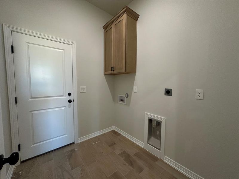 Laundry room with wood finished floors, electric dryer hookup, cabinet space, and washer hookup