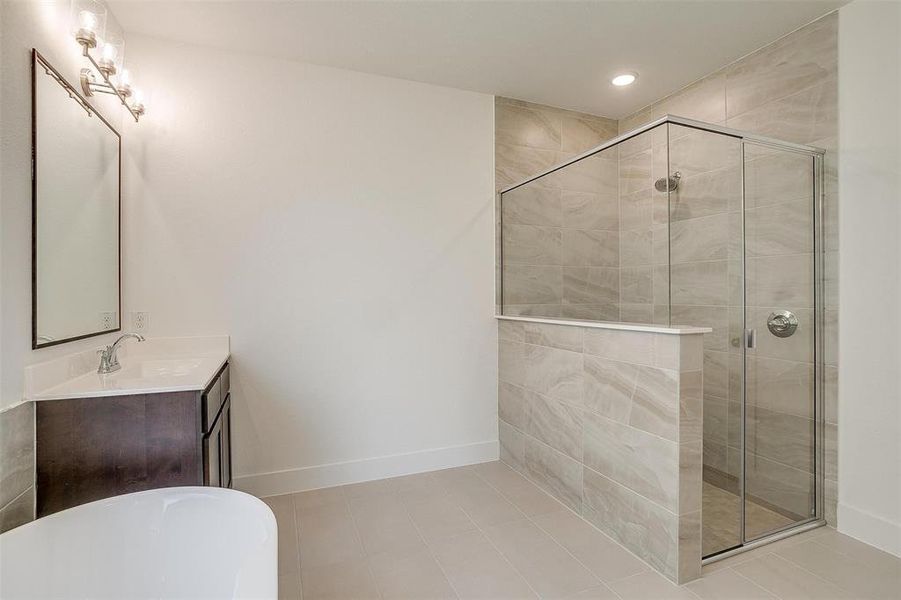 Bathroom featuring independent shower and bath, tile flooring, and large vanity