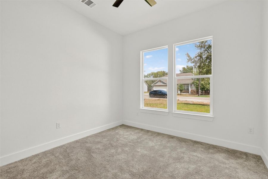 Unfurnished room featuring light colored carpet and a ceiling fan
