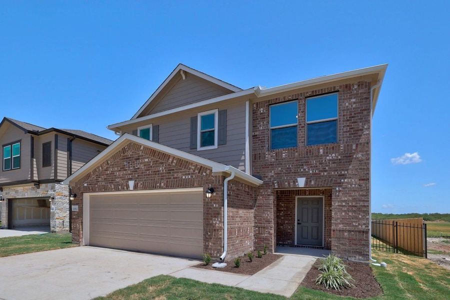 Front exterior of a new home in Stoney Chase, Del Valle, TX, highlighting curb appeal (Image 2). Front exterior of a new home in Stoney Chase, Del Valle, TX, highlighting curb appeal (Image 2).