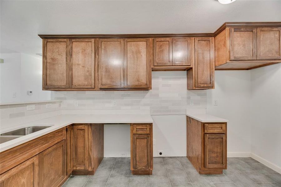 Kitchen with light tile patterned flooring and decorative backsplash