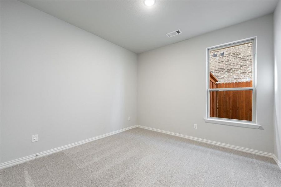Spare room featuring carpet flooring and baseboards