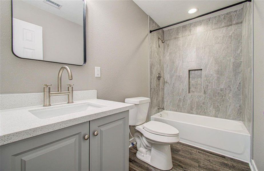 A second bathroom view of the primary highlighting the spacious vanity and beautiful floor-to-ceiling shower tile.