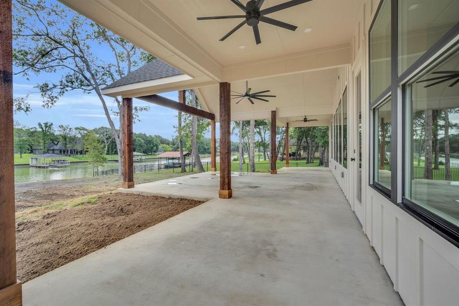 View of patio with ceiling fan and a water view