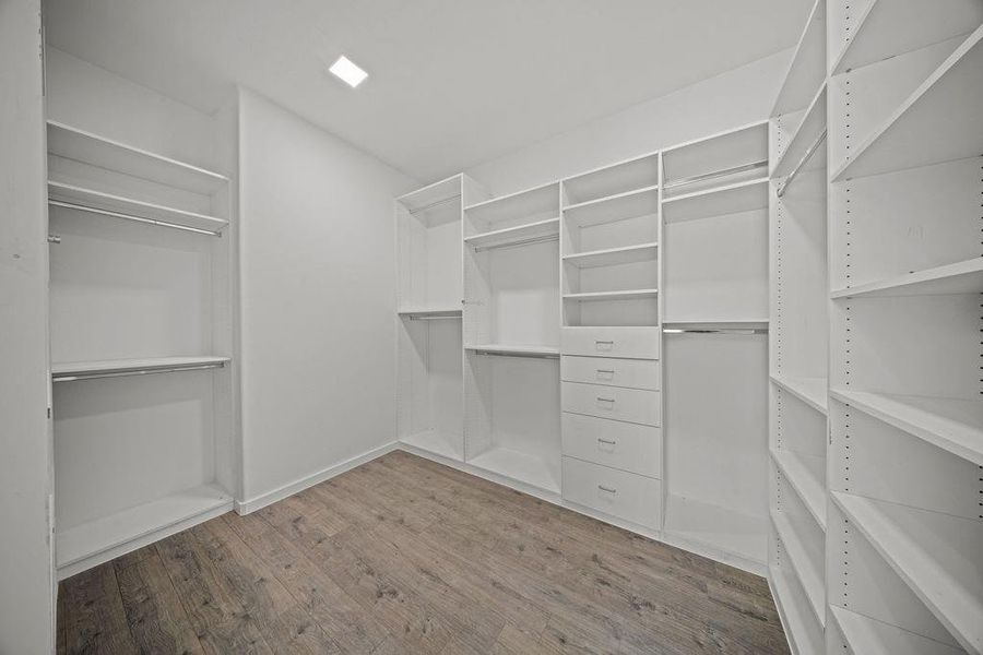 Walk in closet with light wood finished floors