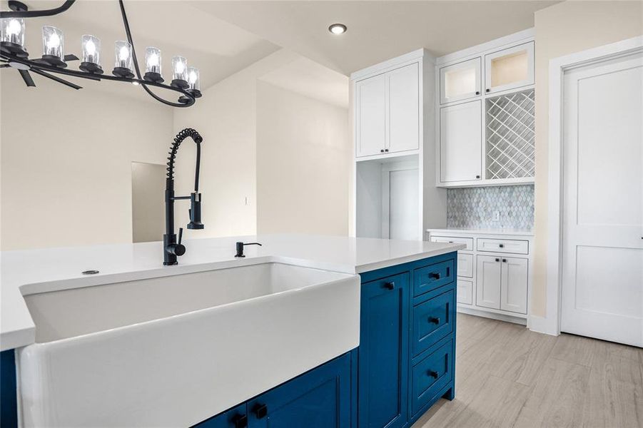 Kitchen featuring blue cabinetry, white cabinets, recessed lighting, light countertops, and hanging light fixtures Kitchen featuring blue cabinetry, white cabinets, recessed lighting, light countertops, and hanging light fixtures