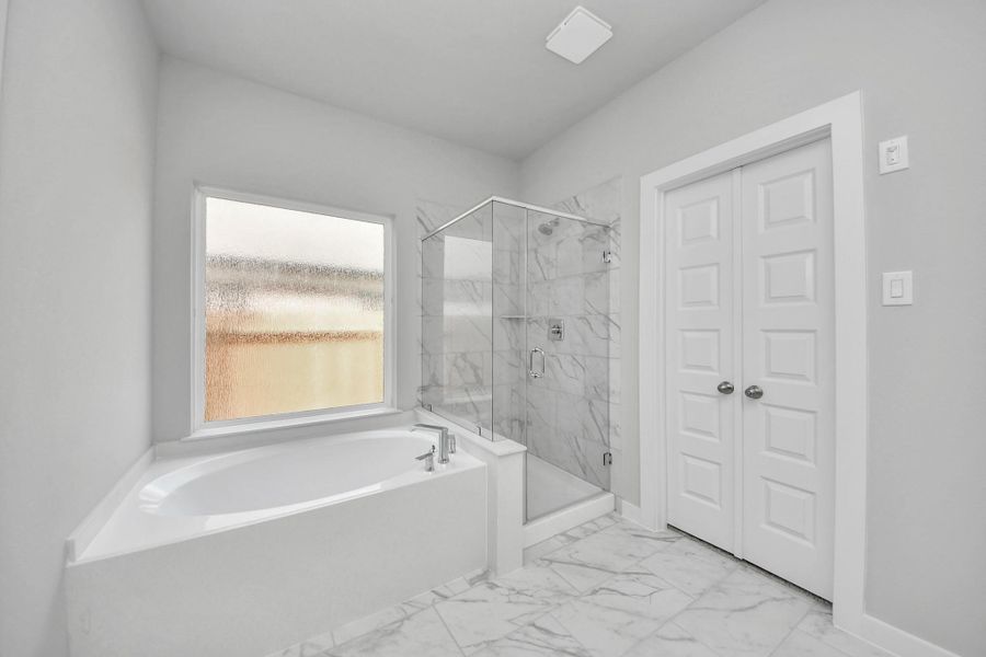 Escape to a spa-like oasis in this primary bathroom. Enjoy a walk-in shower with tile surround, a separate garden tub with custom detailing, and an elegant vanity featuring light countertops, modern hardware, and beautiful recessed lights. Experience luxury and relaxation in every detail! Escape to a spa-like oasis in this primary bathroom. Enjoy a walk-in shower with tile surround, a separate garden tub with custom detailing, and an elegant vanity featuring light countertops, modern hardware, and beautiful recessed lights. Experience luxury and relaxation in every detail!