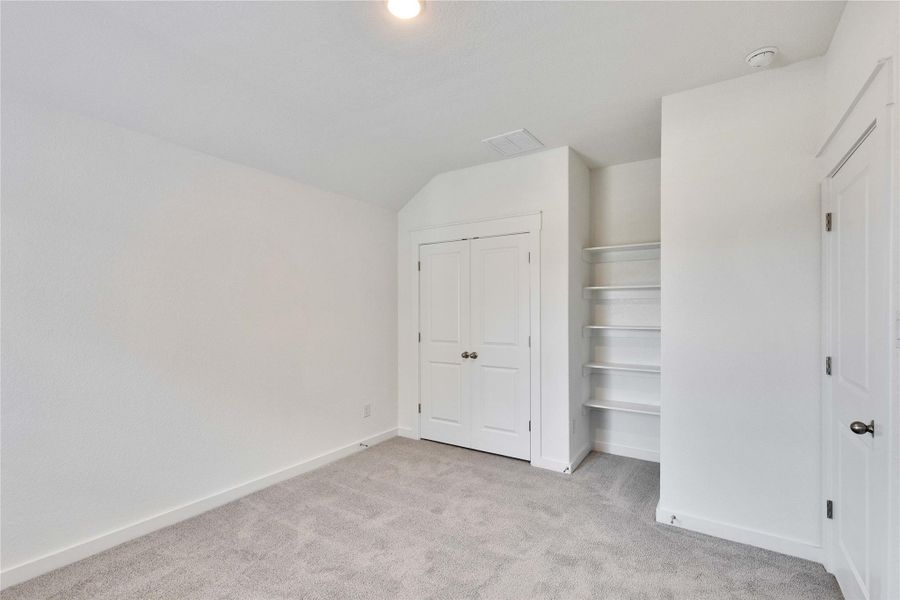 Unfurnished bedroom with light colored carpet and a closet Unfurnished bedroom with light colored carpet and a closet