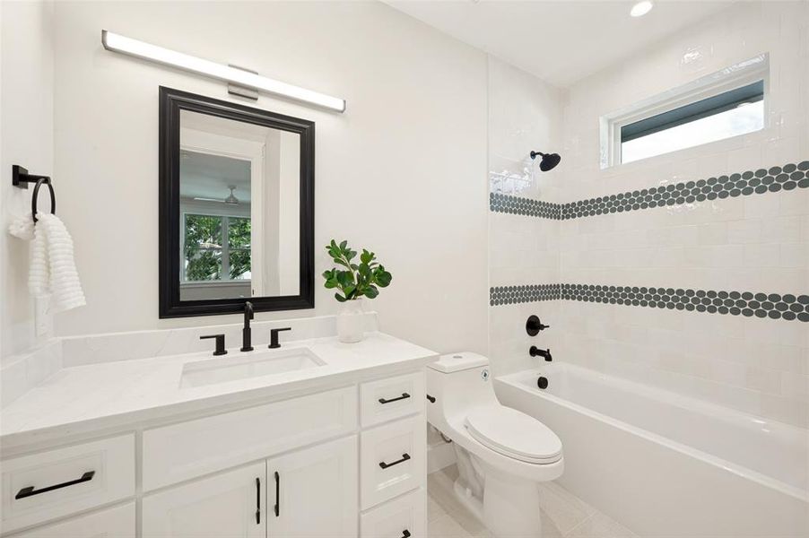Contemporary bathroom featuring a white vanity with integrated sink, quartz countertop, and matte black fixtures