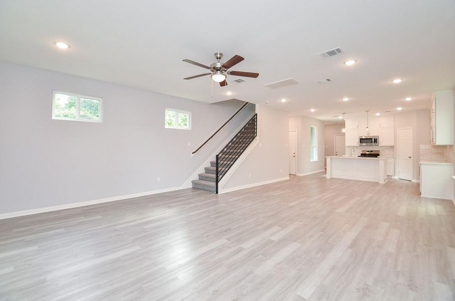 Highlights the airy ceilings and smooth connection to dining/kitchen.
