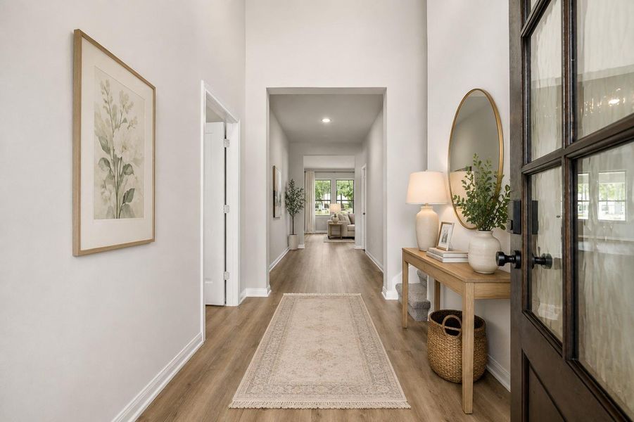 Stunning entryway with high ceilings and elegant lighting, leading to a bright and inviting living area.