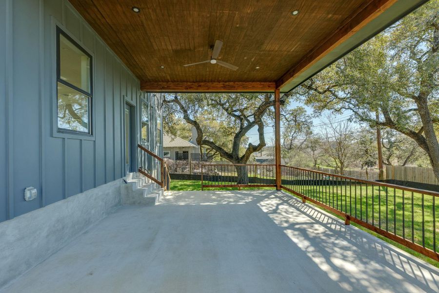 Backyard covered porch with heritage live oak trees.