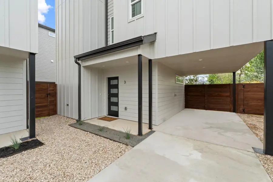 Modern vertical siding and a sheltered concrete driveway frame this contemporary entryway.