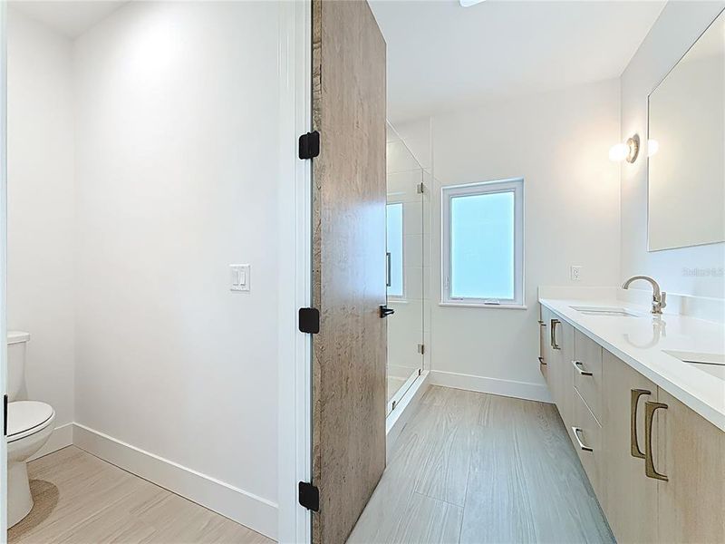 Spa-like en-suite bath featuring dual sinks, an oversized walk-in shower, and a private water closet. Spa-like en-suite bath featuring dual sinks, an oversized walk-in shower, and a private water closet.