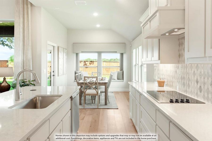 Kitchen with white cabinets, quartz countertops, and breakfast nook with window seating and hardwood floors