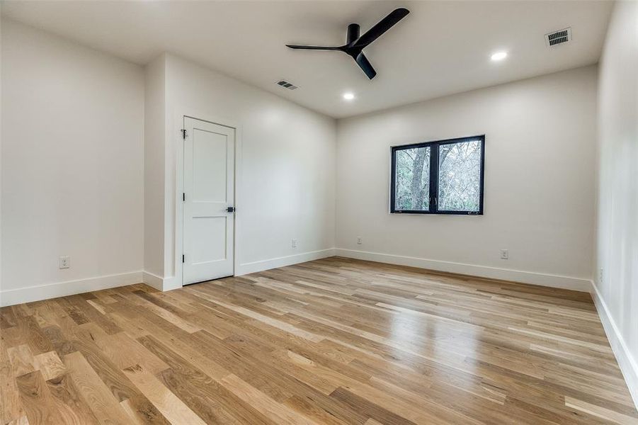 Empty room with ceiling fan and light hardwood / wood-style flooring