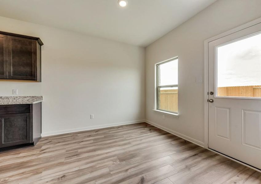 The dining room has back yard views and gorgeous wood-style flooring.