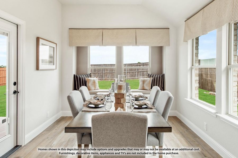 Bright dining room with large windows, wood table, gray upholstered chairs, and light hardwood floors