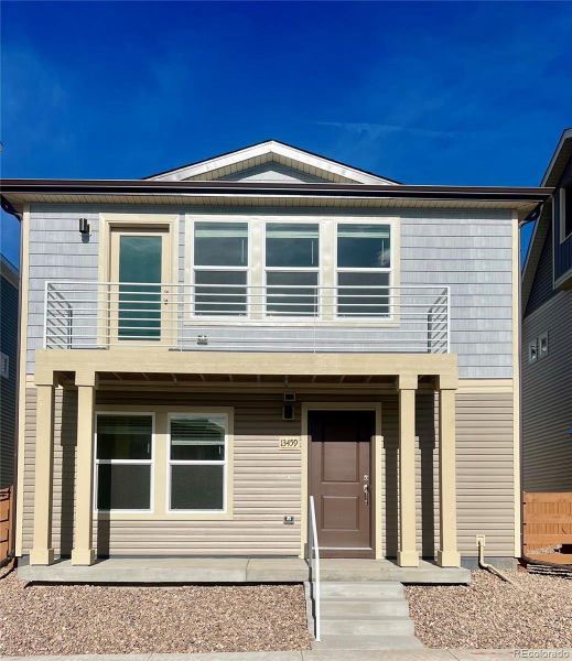Front exterior of a new home in Reunion, Commerce City, CO, highlighting curb appeal (Image 1).