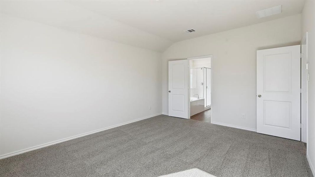 Unfurnished bedroom with vaulted ceiling and carpet flooring Unfurnished bedroom with vaulted ceiling and carpet flooring