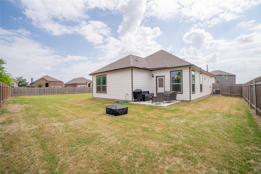 Expansive backyard featuring a privacy fence, concrete patio, and white siding exterior Expansive backyard featuring a privacy fence, concrete patio, and white siding exterior