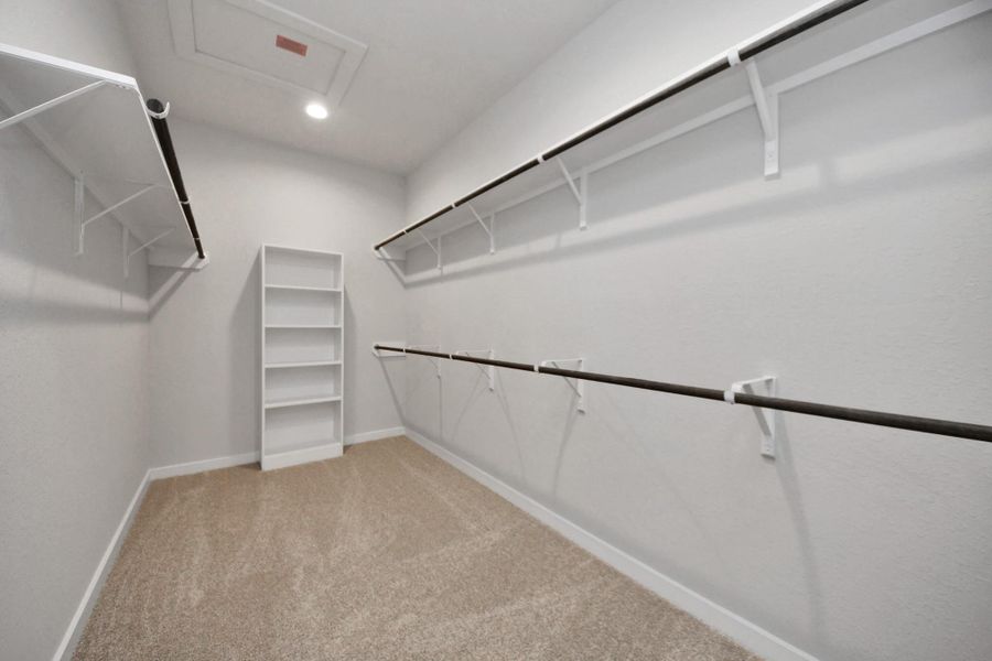 Walk-in closet that epitomizes luxury and practicality. This generously sizedspace features built-in shelving, offering abundant room for impeccableorganization. High ceilings and recessed lighting create a bright andwelcoming ambiance. Sample photo of completed home with similar floor plan. Actual colors and selections may vary. Walk-in closet that epitomizes luxury and practicality. This generously sizedspace features built-in shelving, offering abundant room for impeccableorganization. High ceilings and recessed lighting create a bright andwelcoming ambiance. Sample photo of completed home with similar floor plan. Actual colors and selections may vary.