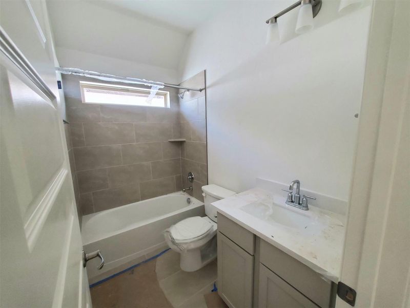 Bathroom with vanity, toilet, and shower / washtub combination