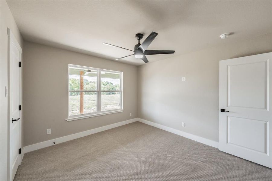 Unfurnished bedroom with light carpet and a ceiling fan Unfurnished bedroom with light carpet and a ceiling fan