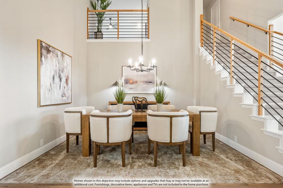 Formal dining room with two-story ceiling, wood table, eight white chairs, chandelier, and staircase nearby. Formal dining room with two-story ceiling, wood table, eight white chairs, chandelier, and staircase nearby.