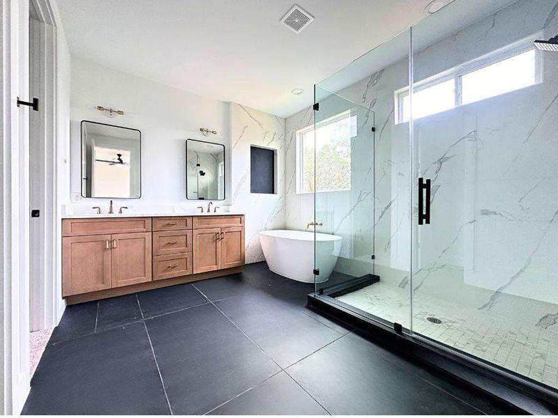 A well-appointed bath features a spacious glass-enclosed shower, a freestanding soaking tub, and a double vanity. A well-appointed bath features a spacious glass-enclosed shower, a freestanding soaking tub, and a double vanity.