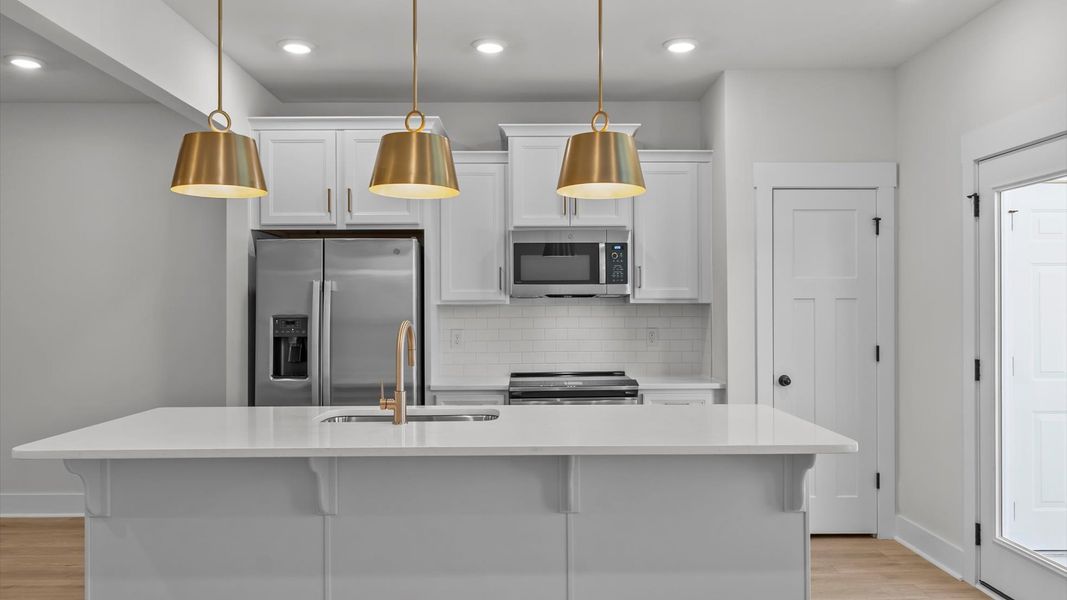 Superior craftsmanship shines in this modern kitchen with a space-saving island and open flow at Gresham Station