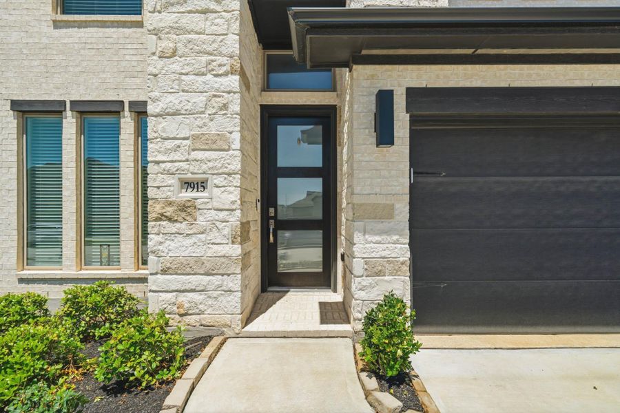 Welcoming front entrance featuring modern finishes and an elegant covered entryway