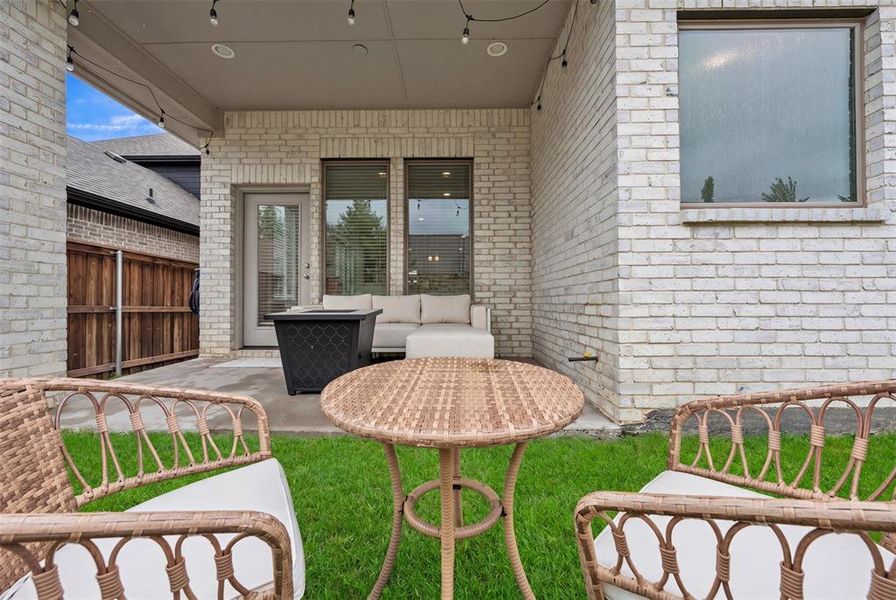 Covered patio area featuring light-toned brick exterior, concrete patio flooring, and a manicured lawn Covered patio area featuring light-toned brick exterior, concrete patio flooring, and a manicured lawn