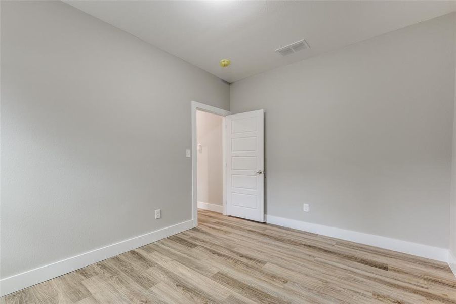 Empty room with baseboards and light wood finished floors