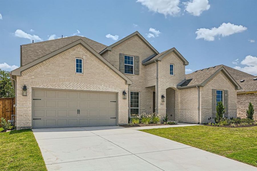 View of front of property with a garage and a front lawn