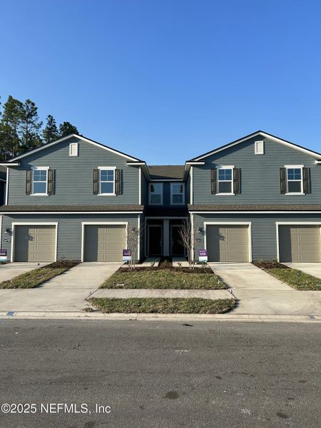 Front exterior of a new home in The Villas at Bishop Oaks, Jacksonville, FL, highlighting curb appeal (Image 1).