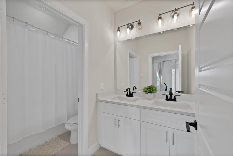 Bathroom featuring a dual vanity with white cabinetry, integrated sinks, and dark-finished faucets Bathroom featuring a dual vanity with white cabinetry, integrated sinks, and dark-finished faucets