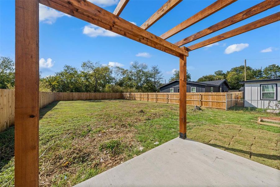 Fenced backyard with a pergola and a patio area
