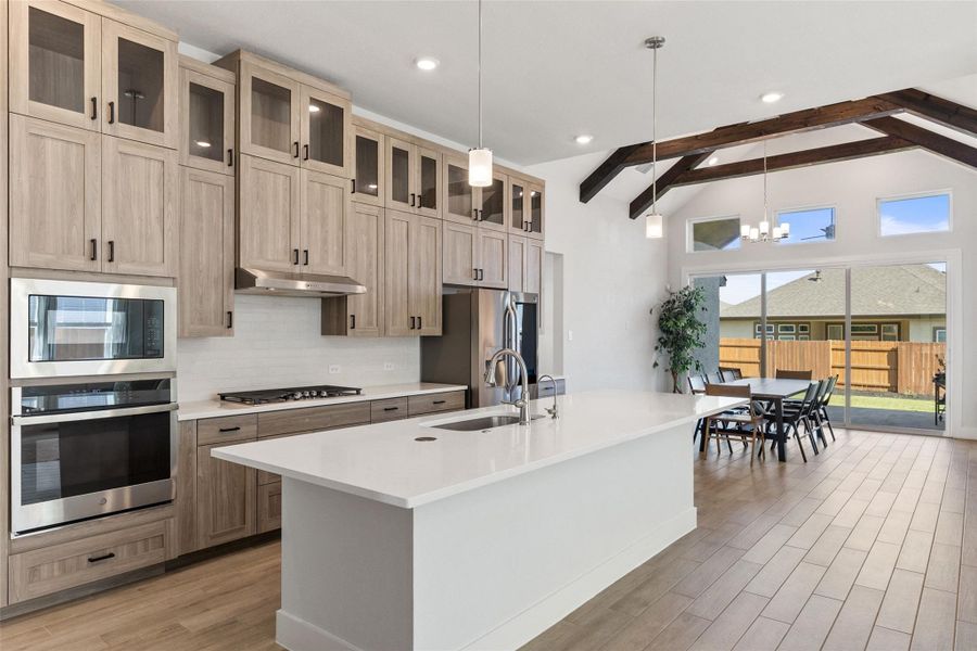 The open-concept layout centers on a generous kitchen island and shaker-style cabinetry.