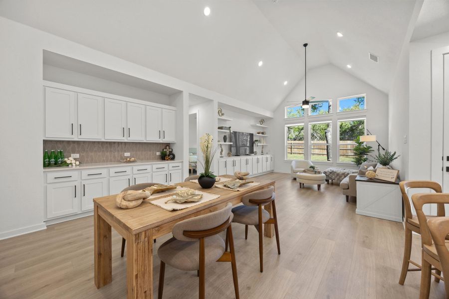 Dining area with a high ceiling, a ceiling fan, light wood-style flooring, and recessed lighting
